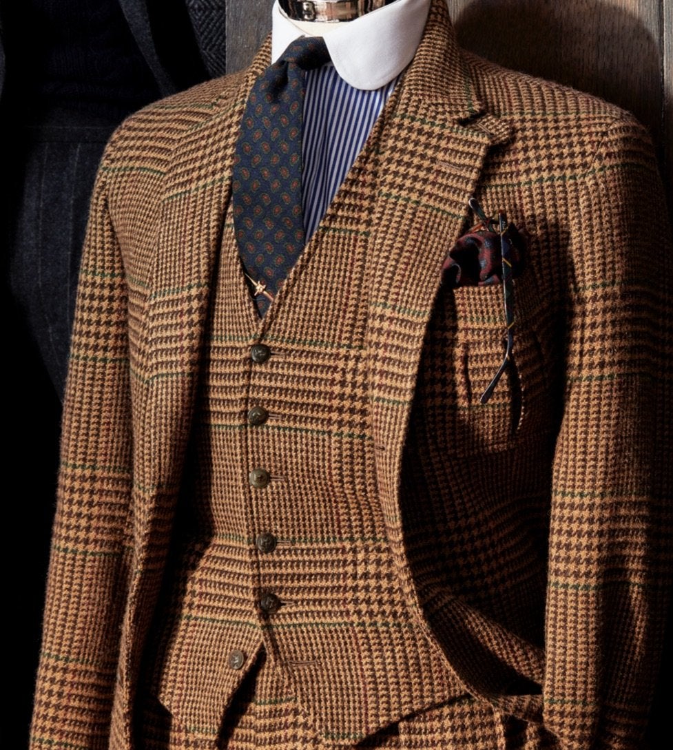 <strong>CHECKED OUT</strong><br/><span>A three-piece suit in a large-scale cognac-and-camel Glen check. The fabric was not only woven exclusively in Britain for the collection; it has a pattern detail that is purely Polo: a windowpane grid of wine and green &ldquo;guard&rdquo; the pattern, meaning the colours run along the edge of the plaid, giving it the unmistakable look of Ralph Lauren</span>